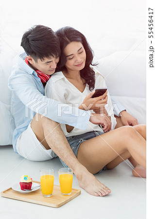 Asian couple sitting on the floor in the bedroom.. 55456417