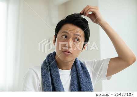 白髪を気にする若い日本人男性 ヘアケアの写真素材