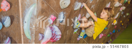 little boy climbing a rock wall in special boots. indoor BANNER, LONG FORMAT little boy climbing a rock wall in special boots. indoor BANNER, LONG FORMAT 55467803