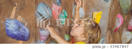 little boy climbing a rock wall in special boots. indoor BANNER, LONG FORMAT little boy climbing a rock wall in special boots. indoor BANNER, LONG FORMAT 55467847