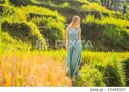 Beautiful young woman walk at typical Asian hillside with rice farming, mountain shape green cascade 55468507