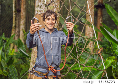 strong young men in a rope park on the wood background strong young men in a rope park on the wood background 55468723