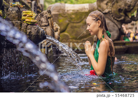 Woman in holy spring water temple in bali. The temple compound consists of a petirtaan or bathing 55468725