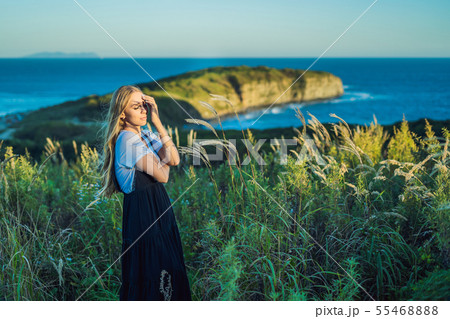 Young beautiful woman in autumn landscape with dry flowers, wheat spikes. Fashion autumn, winter Young beautiful woman in autumn landscape with dry flowers, wheat spikes. Fashion autumn, winter 55468888