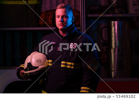 Poirtrait of fireman looking to side near fire truck 55469102