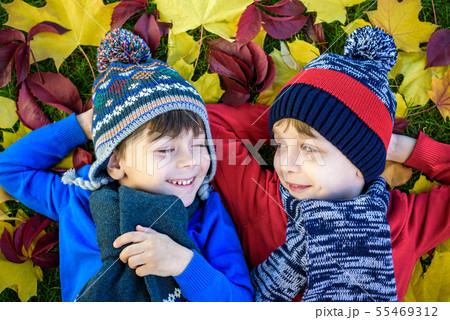 Two little brother kids boys lying in autumn Two little brother kids boys lying in autumn 55469312