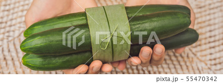 BANNER, LONG FORMAT Eco-friendly product packaging concept. Cucumber wrapped in a banana leaf, as an 55470342