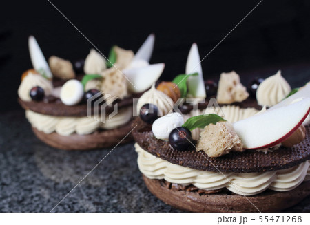 Two chocolate Paris Brest choux pastry rings with hazelnut ganache, nuts, apple slices, black Two chocolate Paris Brest choux pastry rings with hazelnut ganache, nuts, apple slices, black 55471268