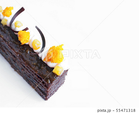 Traditional Sacher cake with apricot pieces and orange microwave sponge decoration on white 55471318