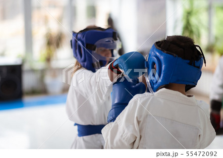 Girl and boy having fight while wearing protective gloves and helmets Girl and boy having fight while wearing protective gloves and helmets 55472092