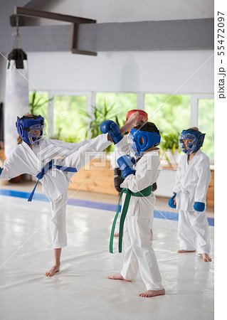Boys and girl having a fight while studying martial art Boys and girl having a fight while studying martial art 55472097