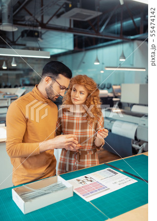 Red-haired beautiful graphic designer looking at colleague 55474142