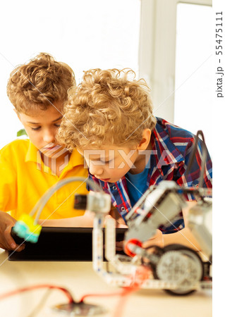 Serious smart boys thinking about the robot Serious smart boys thinking about the robot 55475111
