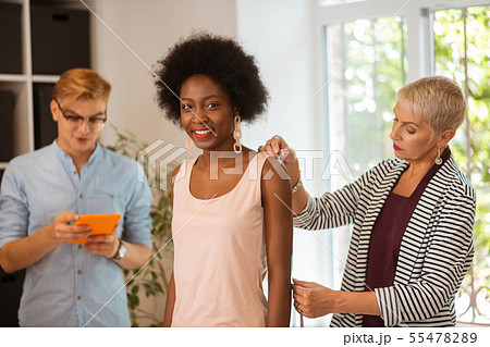 Designer measuring the sleeve length of a young model 55478289