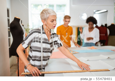 Stylish Caucasian woman tailor standing in a studio 55478401