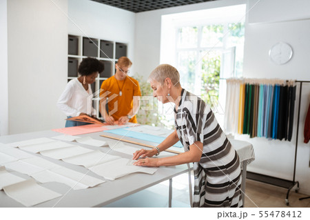 Serious female fashion designer working on a pattern Serious female fashion designer working on a pattern 55478412
