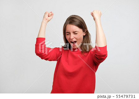 happy caucasian woman in red sweater exults 55479731