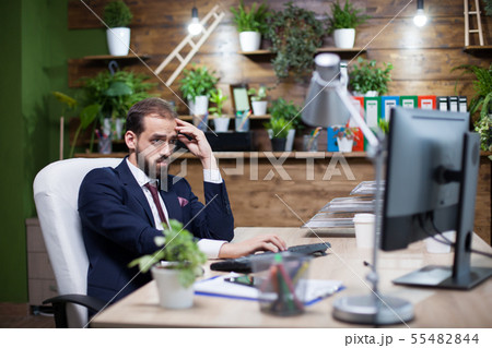 Portrait of bearded young entreprenur concentrating hard on the task 55482844