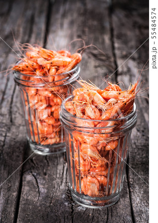 Shrimps in glass tumbler on wooden background. Shrimps in glass tumbler on wooden background. 55484574