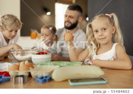 Positive blonde girl holding an egg in her hand 55484602