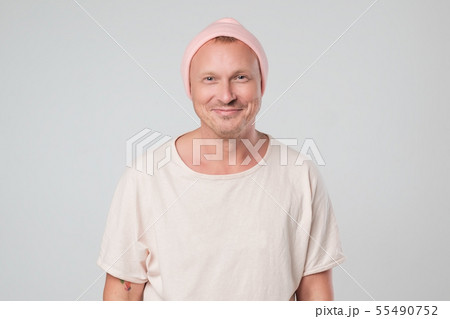 Happy young guy in pink hat looking at camera  55490752