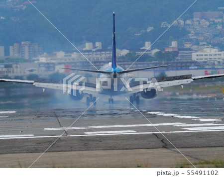 大阪国際空港に着陸するジェット旅客機 55491102