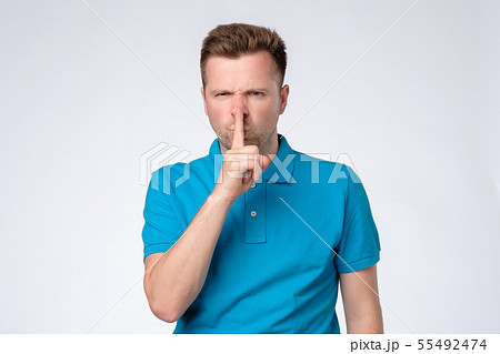 Serious good looking man keeps fore finger Serious good looking man keeps fore finger 55492474