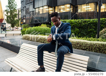 Businessman looking at his watch in office Businessman looking at his watch in office 55493270