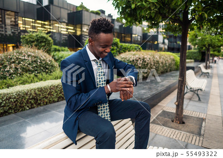 Businessman looking at his watch in office Businessman looking at his watch in office 55493322