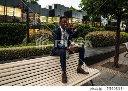 African American businessman holding mobile phone wearing blue suit African American businessman holding mobile phone wearing blue suit 55493334