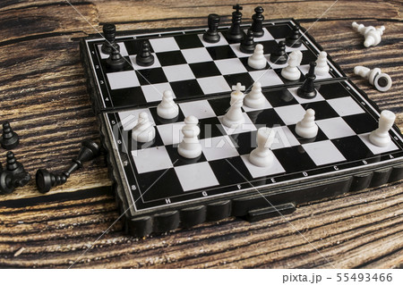 Small pocket chess on a wooden table Small pocket chess on a wooden table 55493466