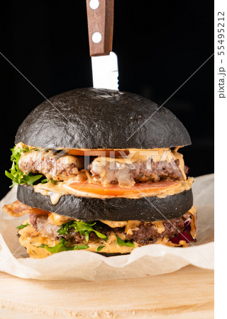 An appetizing black hamburger on the wooden background 55495212