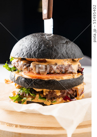 An appetizing black hamburger on the wooden background 55495402