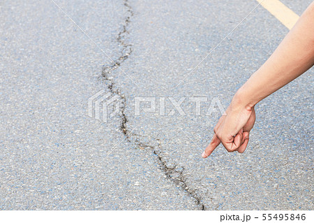hand finger pointing inspect cracked asphalt road 55495846