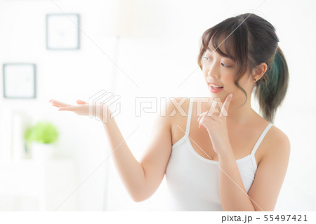 Beautiful young asian woman smiling and showing 55497421