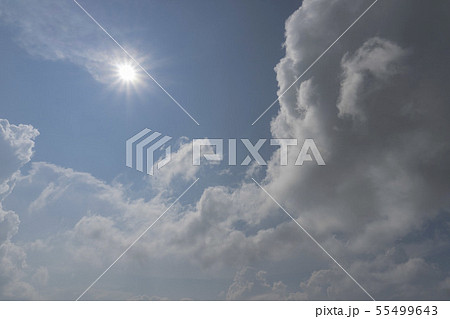 夏の空 青空と太陽を左上にして積乱雲が湧き上がる写真の写真素材