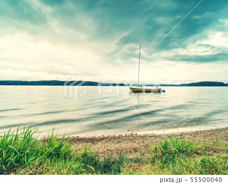 Boat on calm water. Yacht on water near the coast. 55500040