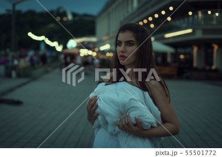 Sad woman wrapped in a white blanket. Sad woman wrapped in a white blanket. 55501772