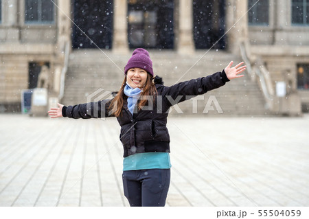 Asian Young woman playing the snow when Snow just fell, travel and excited concept, wool hat with scart and overcoat for winter season Asian Young woman playing the snow when Snow just fell, travel and excited concept, wool hat with scart and overcoat for winter season 55504059