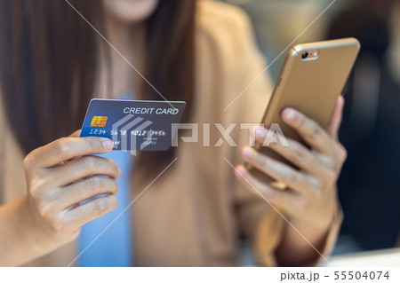 Closeup Asian woman using credit card with mobile for online shopping in department store over the clothes shop store background, technology money wallet and online payment concept, credit card mockup Closeup Asian woman using credit card with mobile for online shopping in department store over the clothes shop store background, technology money wallet and online payment concept, credit card mockup 55504074