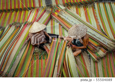 Top view of old Vietnamese lover craftsman making the traditional vietnam mats in the old traditional village at dinh yen, dong thap, vietnam, tradition artist concept 55504089