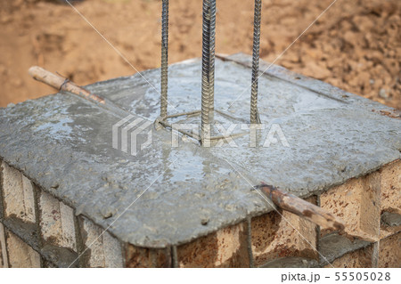 Pouring concrete into steel box for foundation pillar in process of house building Pouring concrete into steel box for foundation pillar in process of house building 55505028