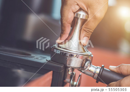 Hand of barista holding coffee tamper and making coffee preparation Hand of barista holding coffee tamper and making coffee preparation 55505303