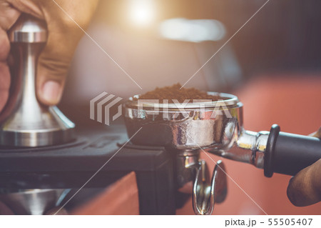 Hand of barista holding coffee tamper and making coffee preparation 55505407