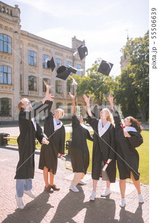 Graduating students throwing their masters caps up. Graduating students throwing their masters caps up. 55506639