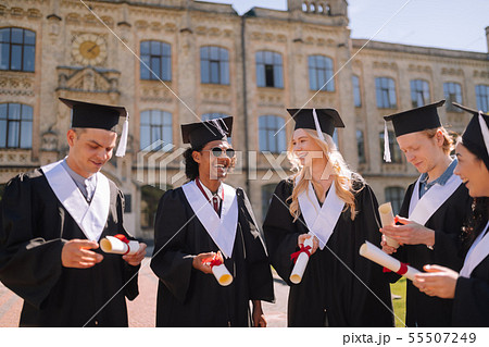 Cheerful graduating students glad having their diplomas. Cheerful graduating students glad having their diplomas. 55507249
