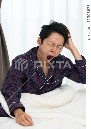 あくびをする日本人男性 不眠症 起床 起きる パジャマの写真素材 