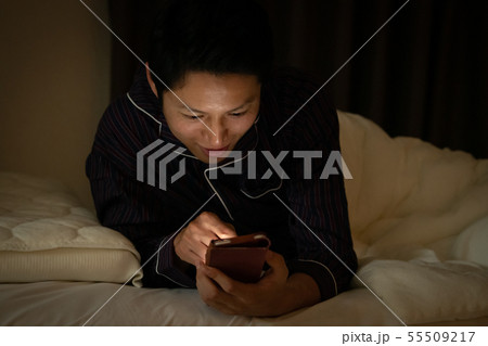 就寝前にスマホを見る日本人男性　ブルーライト 55509217