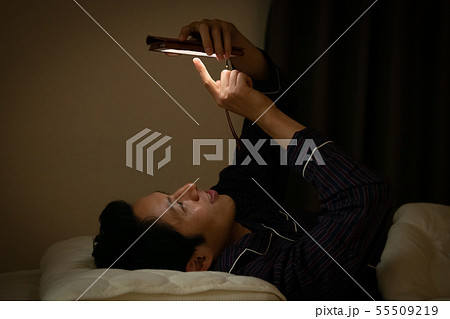就寝前にスマホを見る日本人男性　ブルーライト 55509219