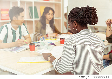 Attentive African American woman staring at her copybook Attentive African American woman staring at her copybook 55509534